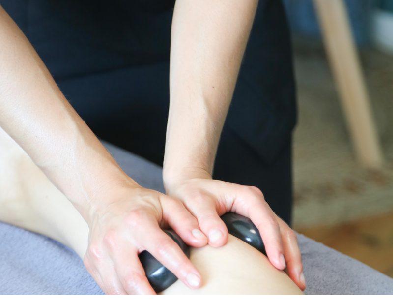 Massage aux pierres chaudes sur les jambes